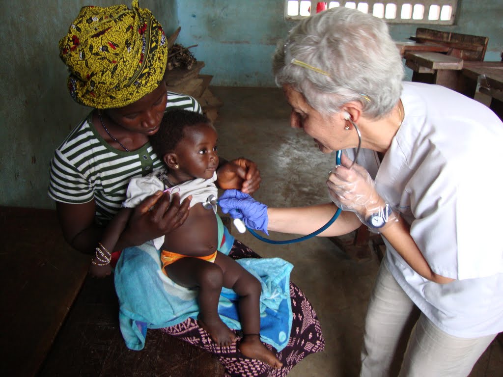 pediatra con fonendoscopio auscultando a un bebé
